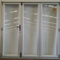 Silver aluminium bi-fold door with dedicated door