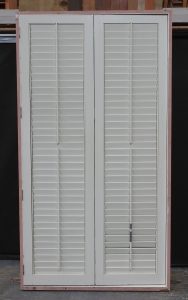 Wooden bi-fold door with awning toplight and shutters