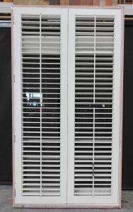 Wooden bi-fold door with awning toplight and shutters